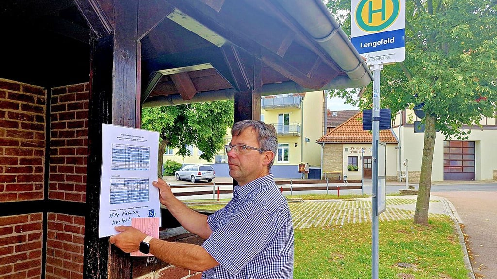 Sven Mehlhase, Mitglied des Ortschaftsrats, hängt in Lengefeld den Fahrplan für die Sonderfahrten zum Kobermännchenfest aus.