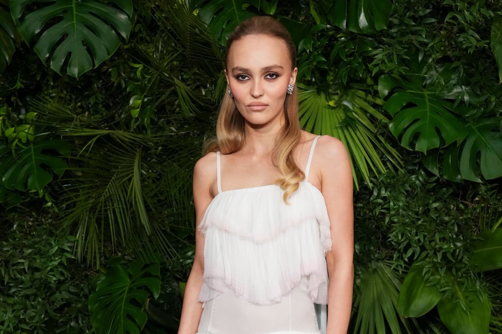 Schauspielerin Lily-Rose Depp schaut in typischer roter Teppich-Pose mit kühler Miene in die Kamera. (Archivbild)