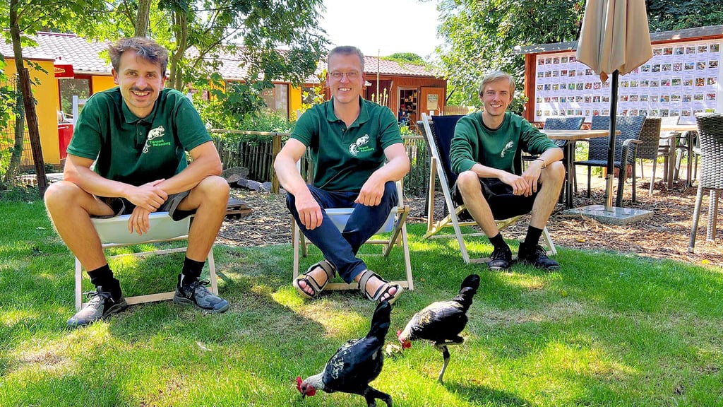 Tierparkleiter Phillip Rose (v.l.), Geschäftsführer Matthias Haak und Tierpfleger Johannes Bartsch freuen sich über den neuen Außenbereich samt Imbiss (im Hintergrund) im Petersberger Tierpark.