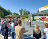 Bürgermeister Torsten Seelig (CDU) begrüßt vor der neuen Bergwitzer Einfeld-Turnhalle zahlreiche Gäste zum Rohbaufest – im Hintergrund das bunte Fassadenkunstwerk, das von Schülerideen inspiriert wurde.