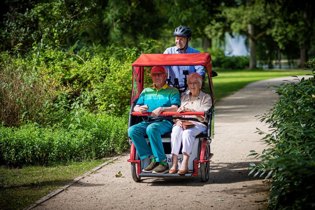 Ehrenamtliche unternehmen mit den Rikschas Ausflüge mit älteren Menschen.