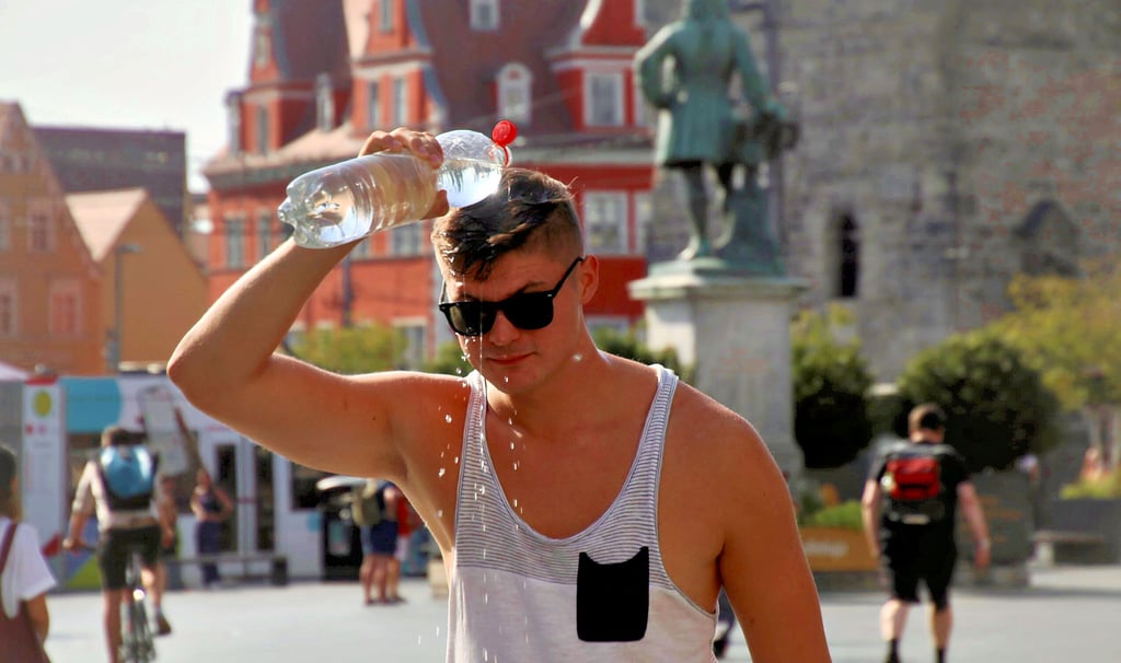 So kann man sich natürlich auch abkühlen: Ein junger Mann schüttete sich auf dem Markt Wasser über den Kopf.
