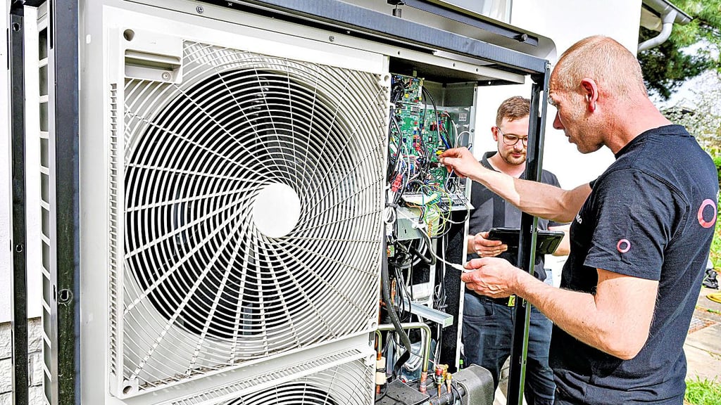 Handwerker stellen eine Wärmepumpe ein.