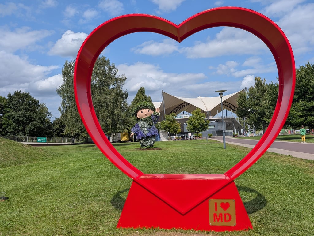 Das Sandmännchen winkt durch das neue XXL-Herz im Elbauenpark Magdeburg – direkt vor der Seebühne lädt der neue Fotospot zum Verweilen und Fotografieren ein.