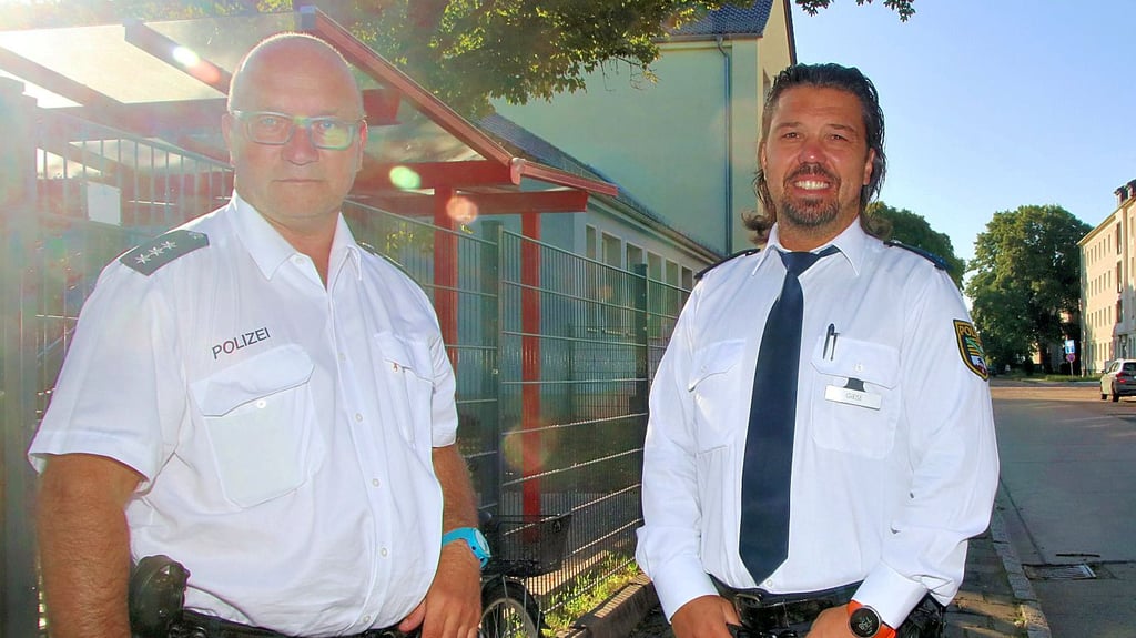 Die Calbenser Polizeibeamten André Bellmann (l.) und Dominik Giese an der Grundschule.