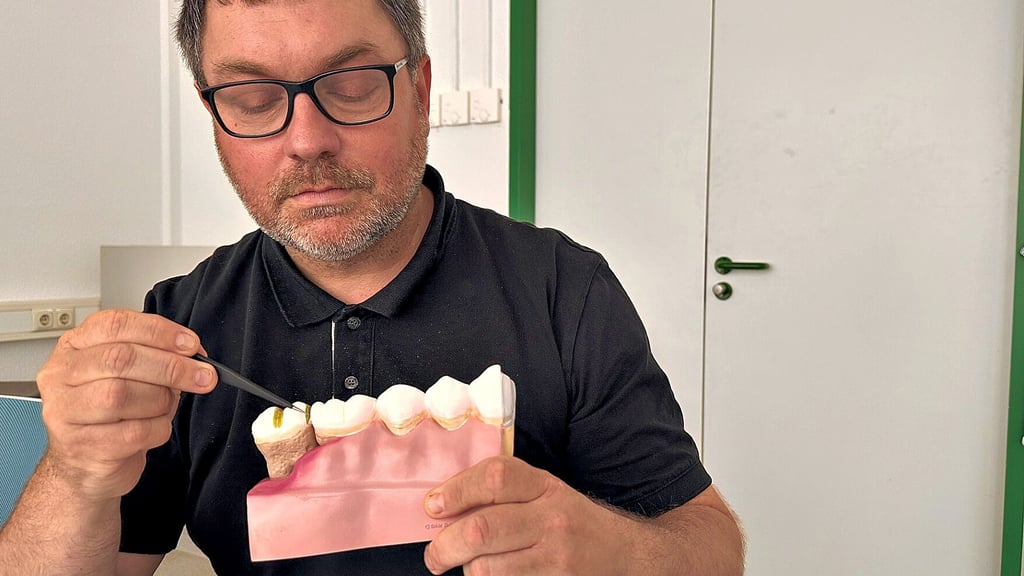 Mirko Buchholz zeigt am Modell eine Zahnfleischentzündung. Die Produkte der Firma sollen sie verhindern.