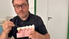 Mirko Buchholz zeigt am Modell eine Zahnfleischentzündung. Die Produkte der Firma sollen sie verhindern.