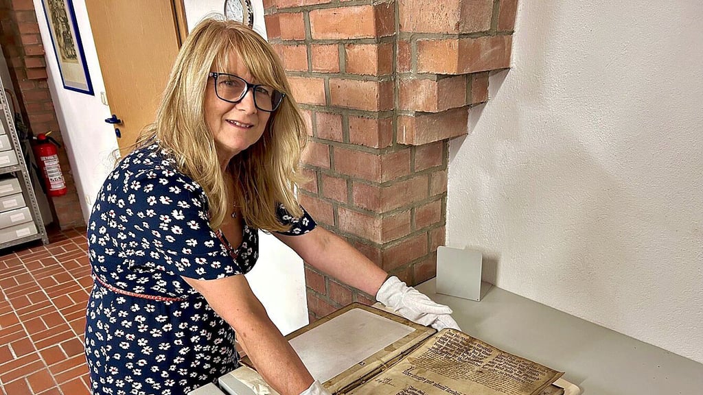 Merseburgs Stadtarchivarin Sylvia Kretzschmar zeigt das älteste Exponat, ein 1445 angelegtes Stadtbuch.