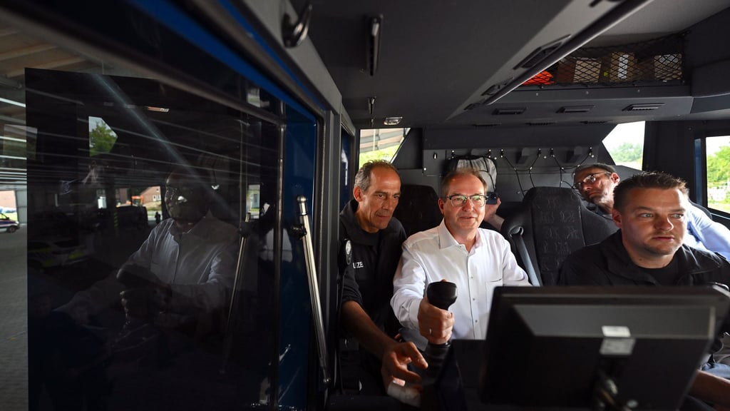 Bundesinnenminister Alexander Dobrindt lässt sich die Funktionsweise eines Wasserwerfers erklären und steigt dafür auch selbst in das Fahrzeug.