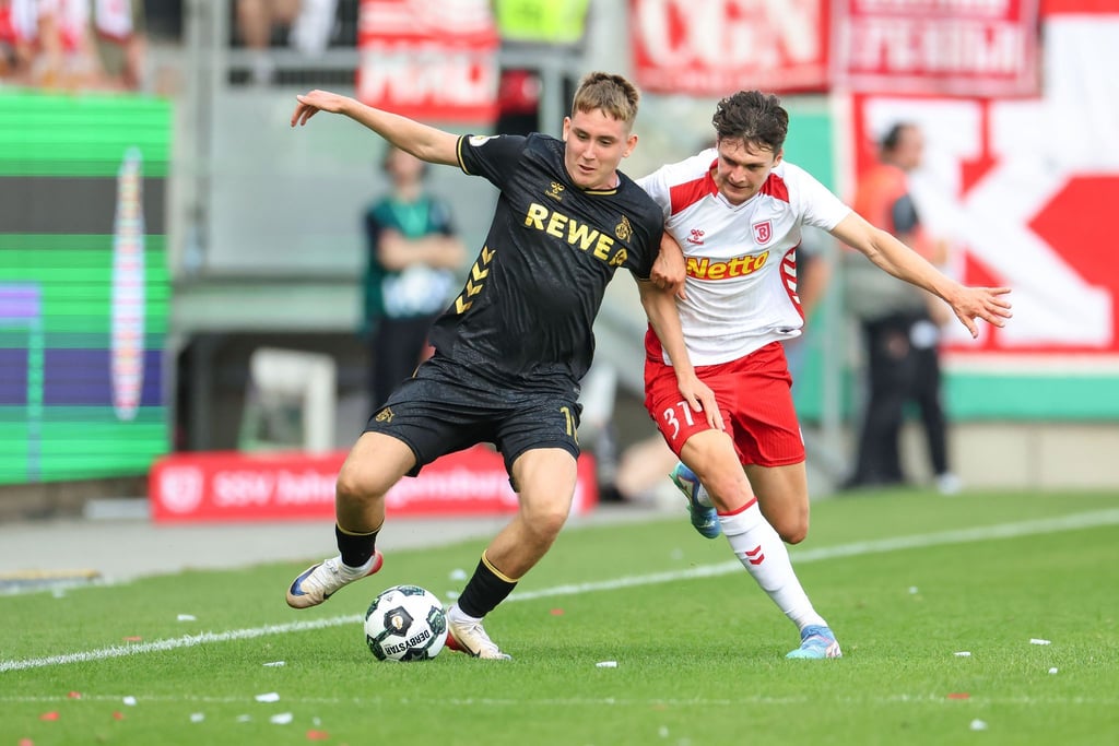 Köln-Neuzugang Isak Johannesson kämpft gegen Regensburg Leo Mätzler um den Ball.