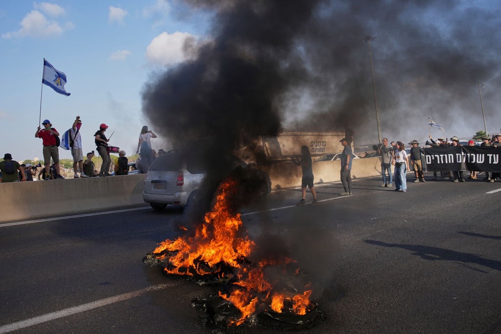 Israelische Demonstranten blockieren eine Straße bei einem Protest.