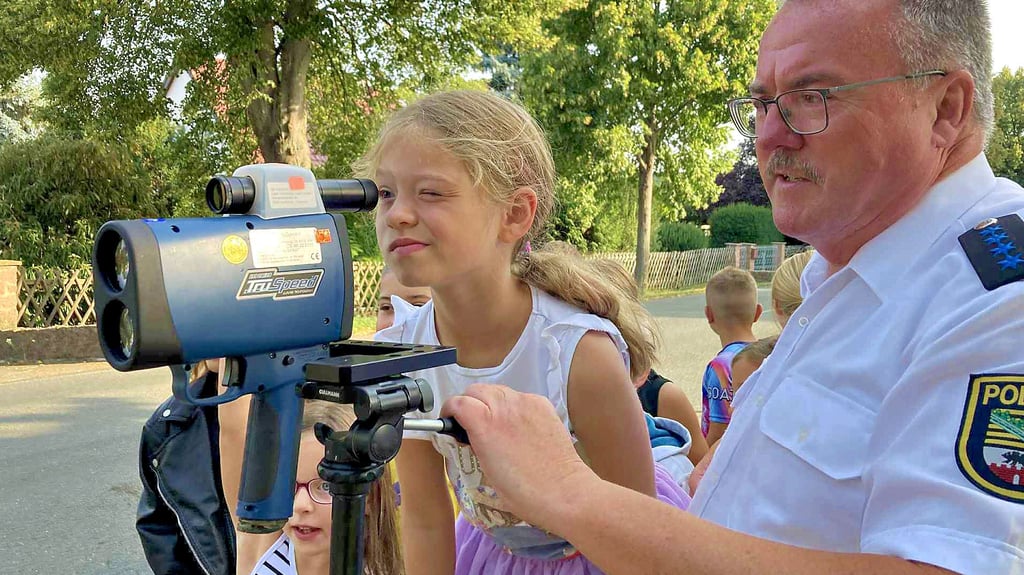 Klaus-Ulrich Schnita zeigt den neugierigen Drittklässlern der Gaterslebener Grundschule, wie das Handlaser-Messgerät funktioniert.