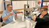  Jean Woithe und Nicole Frenzel (v.l.) verpacken Hygiene-Vliesrollen. Im Hintergrund werden diese für das luftdichte Verschweißen vorbereitet.