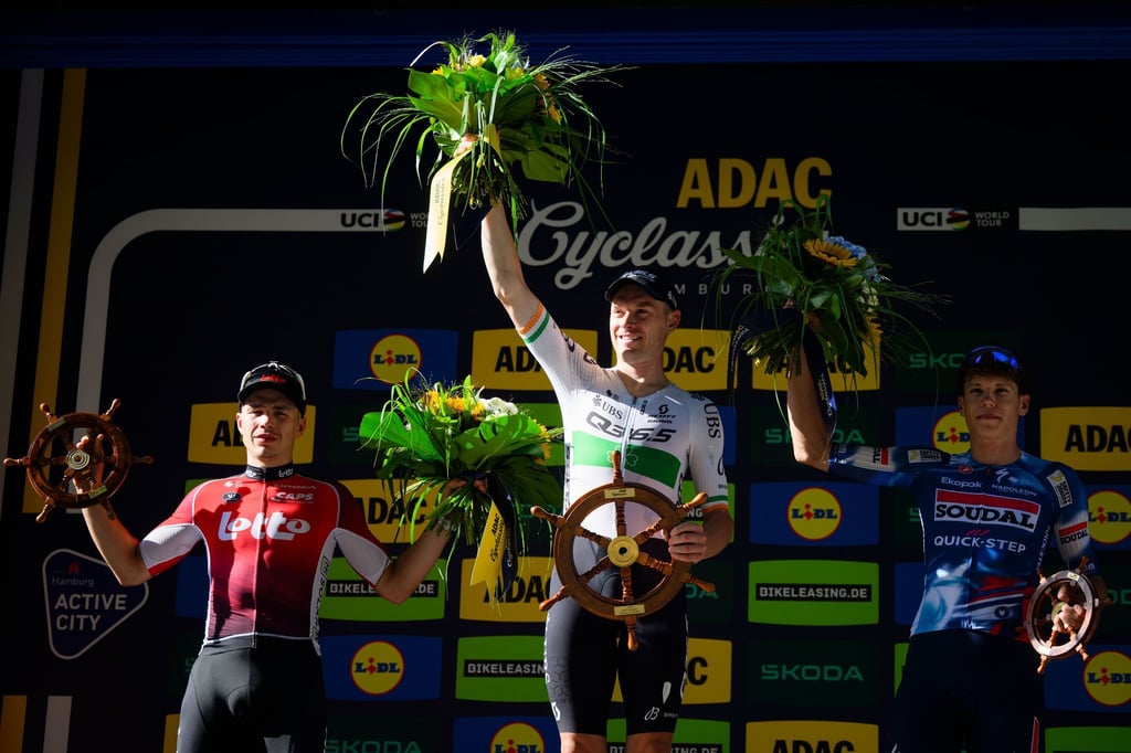 Der zweitplatzierte Belgier Arnaud De Lie (l-r), der Sieger aus Irland Rory Townsend und der drittplatzierte Franzose Paul Magnier bei der Siegerehrung der Cyclassics.