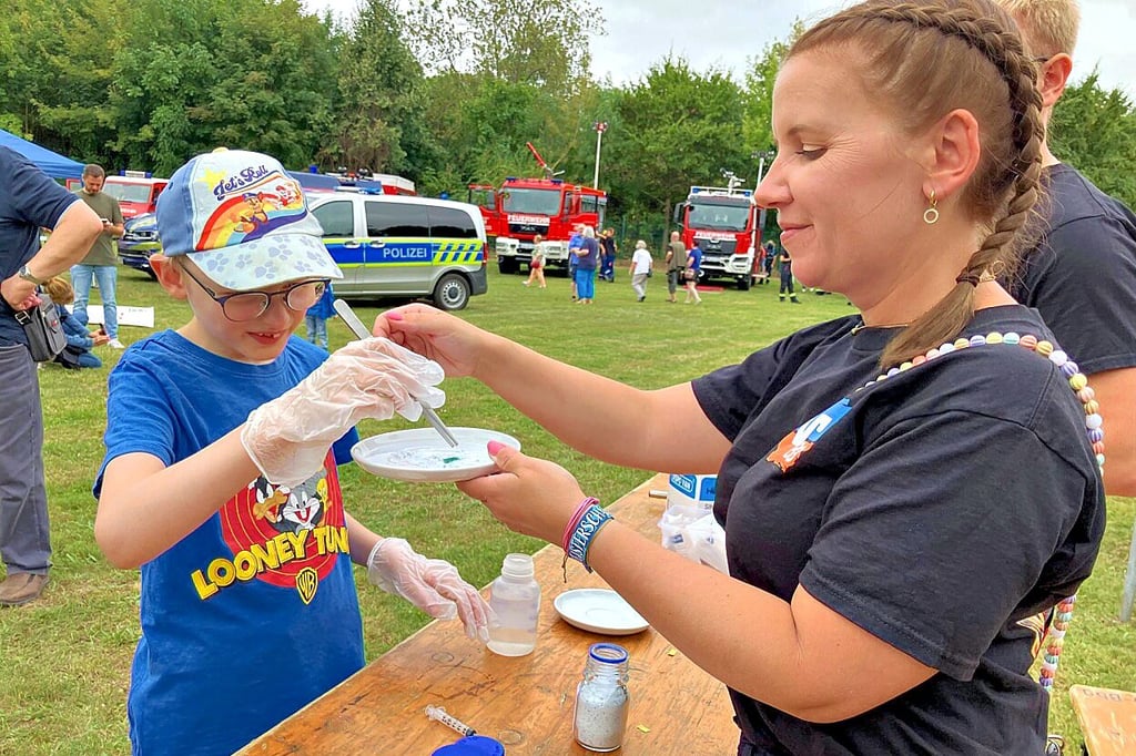 Feuerwehrfrau Juliane Schumann (re.) zeigt Max (9), wie man chemische Stoffe nachweisen kann.