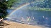 Beim Sommerfest am See in Schönfeld sorgt die Feuerwehr für Wasserspiele und einen Regenbogen. 