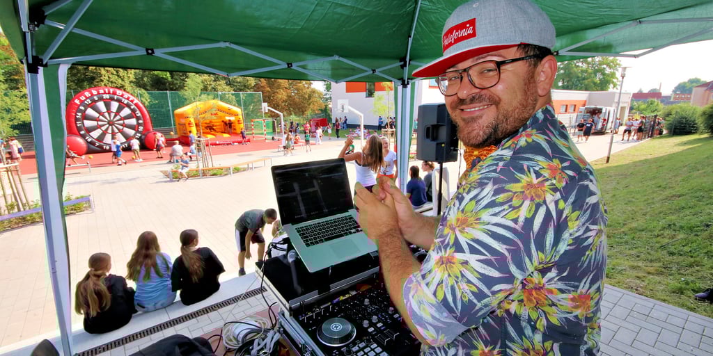 Lars Wohlfahrt macht hier beim Schulfest Musik und heizt den Schülern noch mehr ein.
