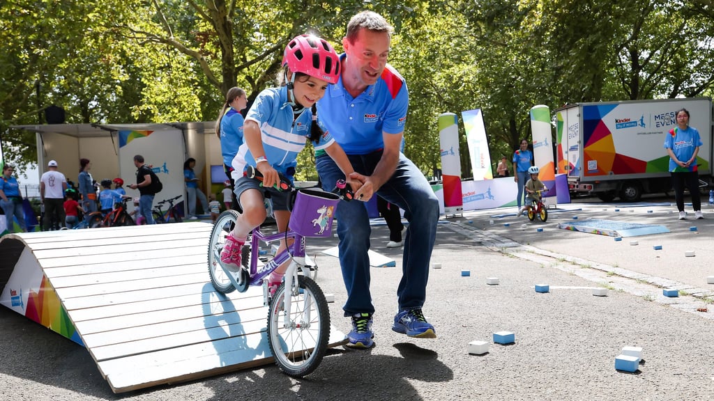 Radsport-Legende Jens Voigt (rechts) versucht, im Rahmenprogramm der Deutschland Tour Kindern den Spaß an der Bewegung zu vermitteln.