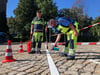 Martin Reinert (l.) und Björn Schumann vom städtischen Bauhof kleben die neue Markierung auf.