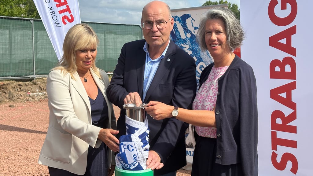 Zeitkapsel statt Spatenstich für das neue FCM-Funktionsgebäude: Magdeburgs Oberbürgermeisterin Simone Borris (l.), FCM-Präsident Jörg Biastoch und Innenministerin Tamara Zieschang ließen das Rohr, in dem unter anderem die aktuelle Volksstimme steckt, sinken.