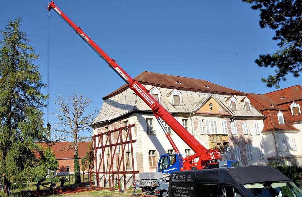 Ein Mobilkran stellt am Südgiebel des Herrenhauses eine stählerne Stützkonstrukion auf. Erst nach umfangreichen statischen Sicherungsarbeiten kann das Dach aufgenommen werden.