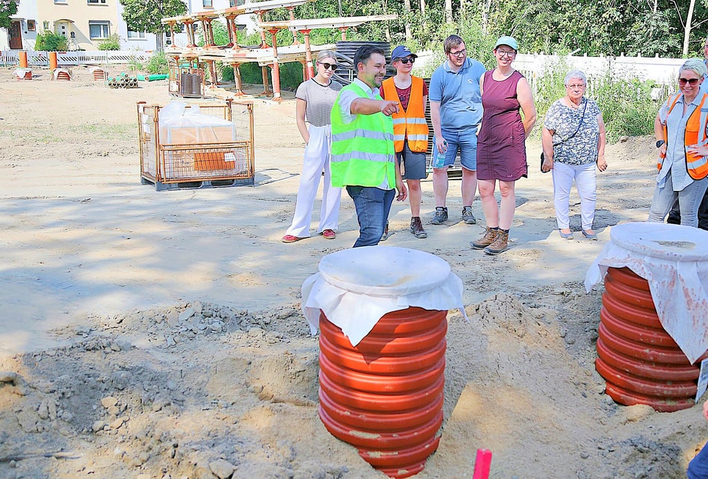 Projektleiter Oliver Schuft (gelbe Weste) präsentiert den Fachexkursionsteilnehmern auf der Baustelle an der Gardelegener Straße/Lüderitzer Straße in Stendal die Bestandteile des neuen Regenrückhaltebeckens.
