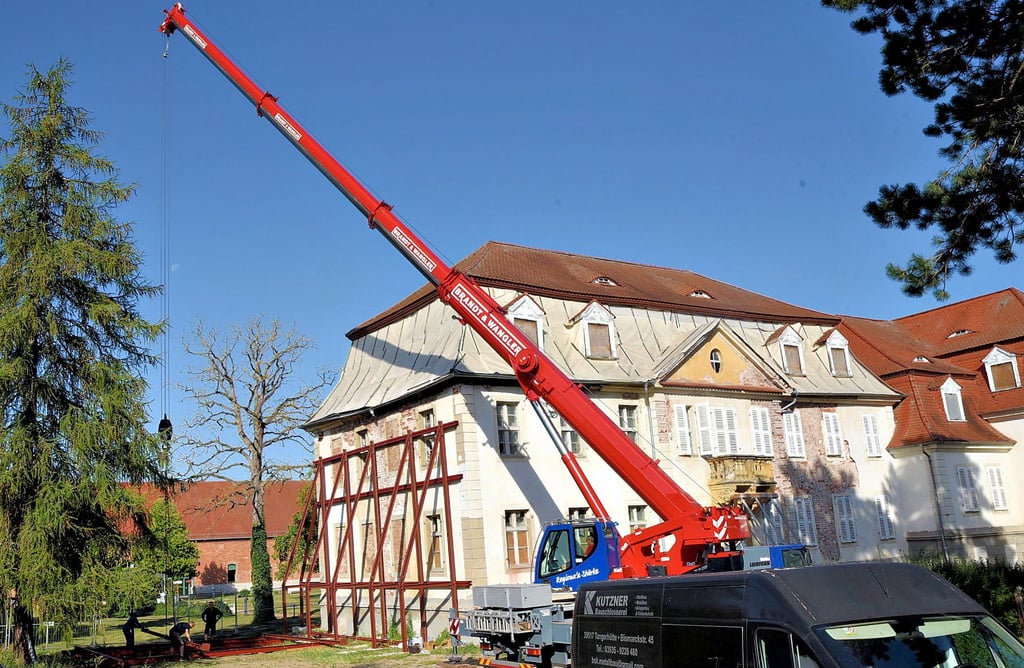 Ein Mobilkran stellt am Südgiebel des Herrenhauses eine stählerne Stützkonstrukion auf. Erst nach umfangreichen statischen Sicherungsarbeiten kann das Dach aufgenommen werden.