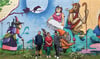Die Graffiti-Künstler Till Neuenfeldt (l.) und Joerg Schnurre (r.) mit Pflegerin Ines Turtschan vor der neuen  Fassade bei der Tagespflege Dießner in Hundeluft. 