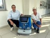 Tobias Mertens, Leiter und Prokurist der Servicegesellschaft im Klinikum Magdeburg, und die stellvertretende Objektleitung Sabrina Fischer mit dem Putzroboter Pudu. 