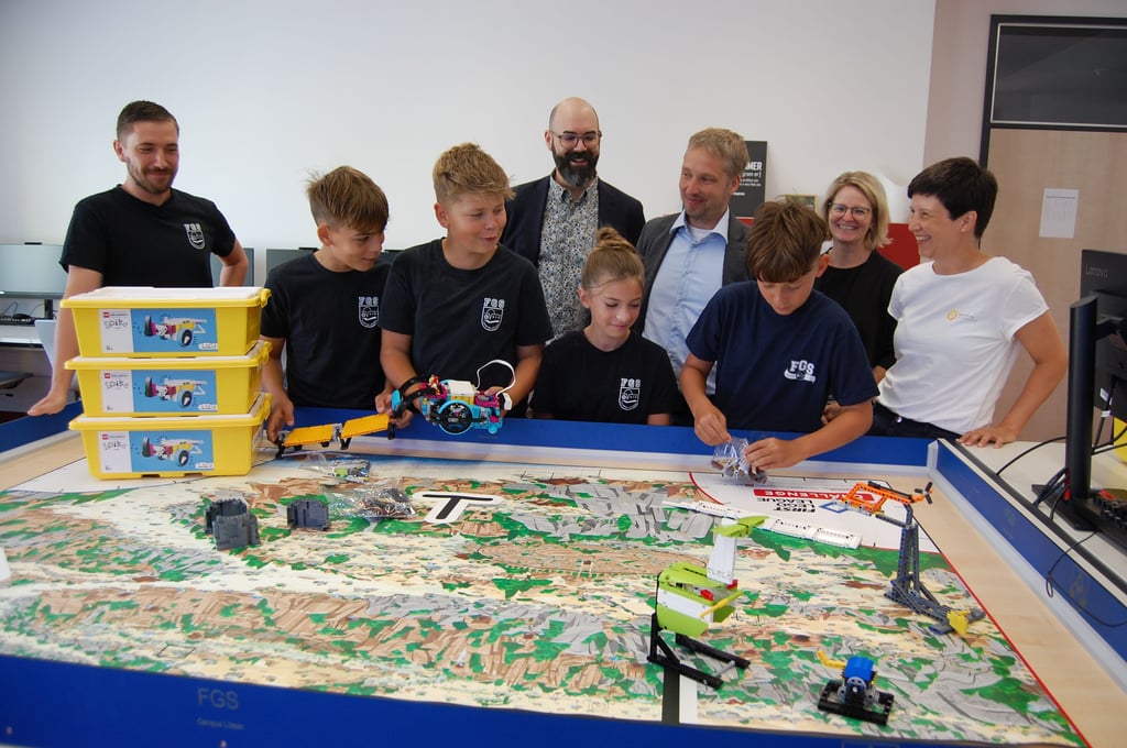 Gemeinsam mit ihrem Lehrer und AG-Leiter Martin Heiler (von l.) und weiteren Unterstützern freuen sich die Schüler Helge, Raffael, Hermine und Benno über ihre neuen Lego-Robotik-Sets.
