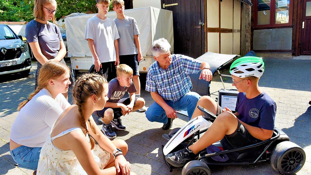 Mentor Peter Holly erklärt den Schülerinnen und Schülern das Kart, das dann noch mit einem Solarmodul versehen wird.