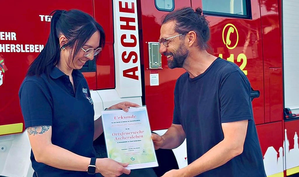Debby Heinze von der Aschersleber Feuerwehr nimmt die Urkunde für den Baum von Silvio Merkwitz vom Verschönerungsverein entgegen.
