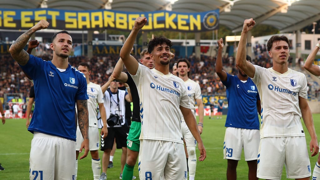 Falko Michel (v. l.), Laurin Ulrich und Noah Pesch feiern den Sieg ihres 1. FC Magdeburgs gegen den 1. FC Saarbrücken.