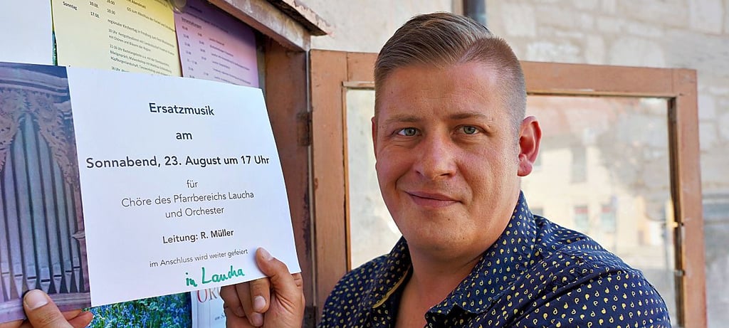 Die eigene Enttäuschung dem Blick nach vorn weichen lassen: Lauchas Kantor Robert Müller hängt das Ankündigungsplakat für die sogenannte Ersatzmusik aus.