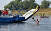 Was für ein Symbolfoto: Weil die Rosenburg-Werkleitzer Fähre infolge Trockenheit seit Wochen nicht pendelt, spazierte ein Mann aus Tornitz ganz gemütlich durch den Fluss.  Heiner Möbus hatte seine Wertsachen in einen Beutel getan, um beim jüngsten Saaletag auf der Rosenburger Seite ein Bier zu trinken.