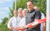 Frank Nase, Franz-Ulrich Keindorff,  Reinhard Lüder und Ortsbürgermeister Christopher Schulte (von links) durchschneiden das Band des neuen Radwegs - auch trotz des fehlenden letzten Meters.