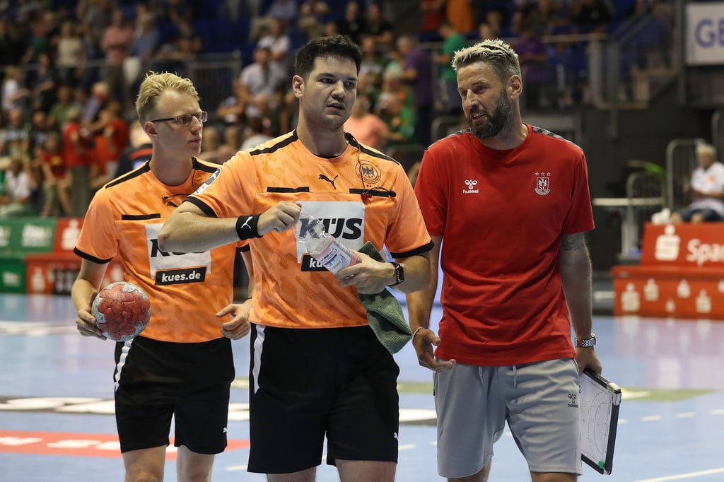 SCM-Trainer Bennet Wiegert (r.) spricht bei Hummel Cup in der Halbzeit auf dem Weg in die Kabine mit den beiden Schiedsrichtern Julian Fedtke (M.) und Niels Wienrich.