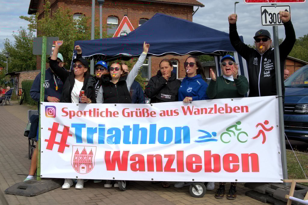 Mitglieder des Vereins Triathlon Wanzleben standen als Fans an der Strecke und feuerten die Fahrer an.