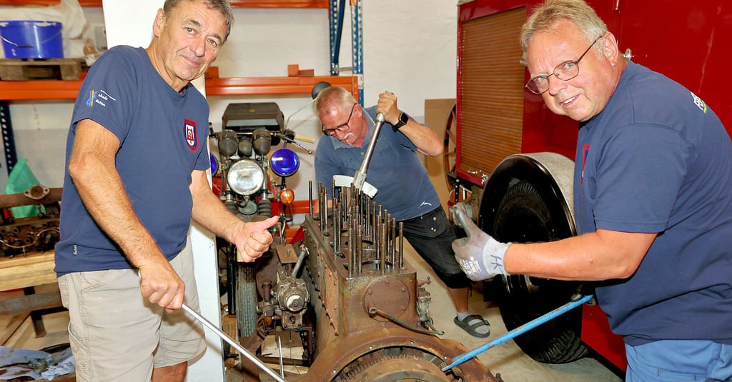 Manfred Seidl (von links), Ingolf Glaß und Herbert Koch bewegen den neu erworbenen Motor – Baujahr 1938.