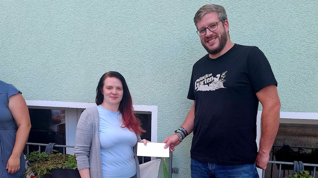 Veranstalter Christian Borger überreicht Mandy Pinske als Initiatorin der Spendenkampange die bei "Rock im Garten" gesammelten Zuwendungen.