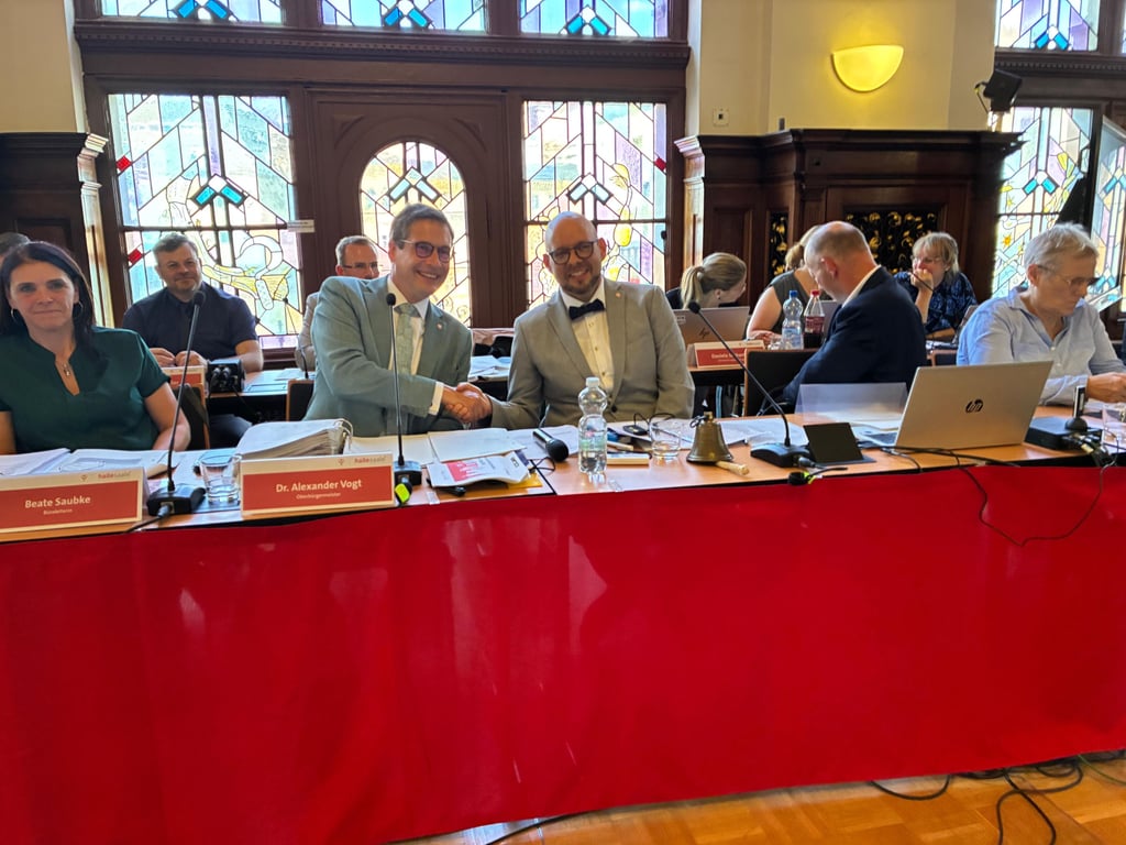 Zum ersten Mal hat Guido Haak (CDU) als neuer Ratsvorsitzender auf dem Podium im Festsaal Platz genommen. Neben ihm sitzt Halles Oberbürgermeister Alexander Vogt (parteilos).