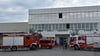 Nach dem Feuerwehreinsatz auf dem Gelände von Refresco im Calvörder Gewerbegebiet: Feuerwehrkräfte haben den Bereich gesichert, während die Mitarbeitenden nach der Entwarnung zurück auf das Firmengelände von Refresco gehen.