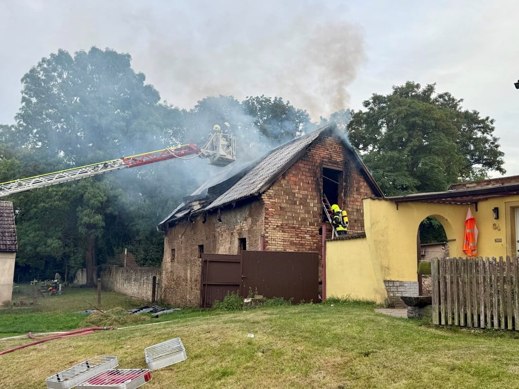Ein Scheunenbrand in Warmsdorf hält die Feuerwehrleute in Atem. Bürger sollen Fenster und Türen geschlossen halten.