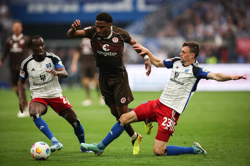 Voll dabei: St. Paulis Oladapo Afolayan (M) kämpft mit Hamburgs Jean-Luc Dompe (l) und Hamburgs Jonas Meffert um den Ball. (Archiv)