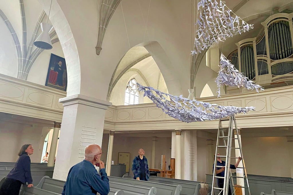 Zeichen des Friedens heißt eine moderne Installation von Sölk Schulze (im Foto von hinten zu sehen) in der Michaeliskirche Zeitz. Am Montag, 1. September, wird sie mit einer Vernissage und Friedensgebet eingeweiht.