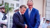 Wie zwei alte Freunde begrüßen sich Macron und Merz vor dem Fort du Cap Brun über der Cote d'Azur.