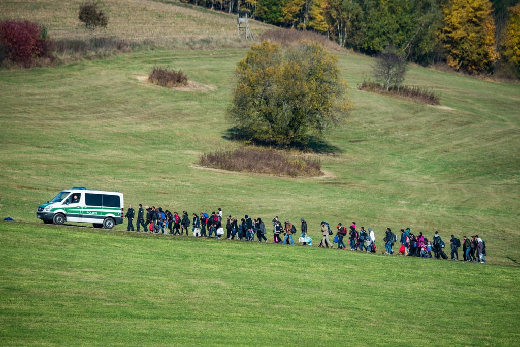 Dieses Foto hat sich bei vielen Deutschen eingebrannt: Flüchtlinge gehen am 27. Oktober 2015 nahe Wegscheid (Bayern) auf einem Feld hinter einem Fahrzeug der Bundespolizei her.