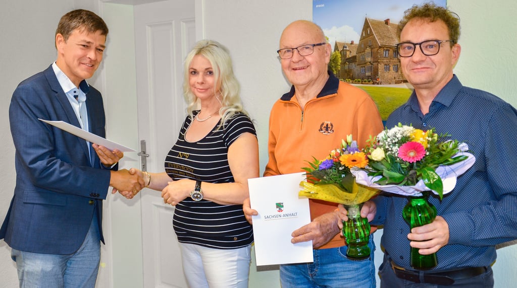 Der Bernburger Amtsgerichtsdirektor Eike Papesch (links) und Saale-Wipper-Verbandsgemeinde-Bürgermeister Jan Ochmann (rechts) würdigen das zehnjährige Engagement von Diana von Zweydorf und Kurt Schuller als Schiedspersonen in der Schiedsstelle Güsten.