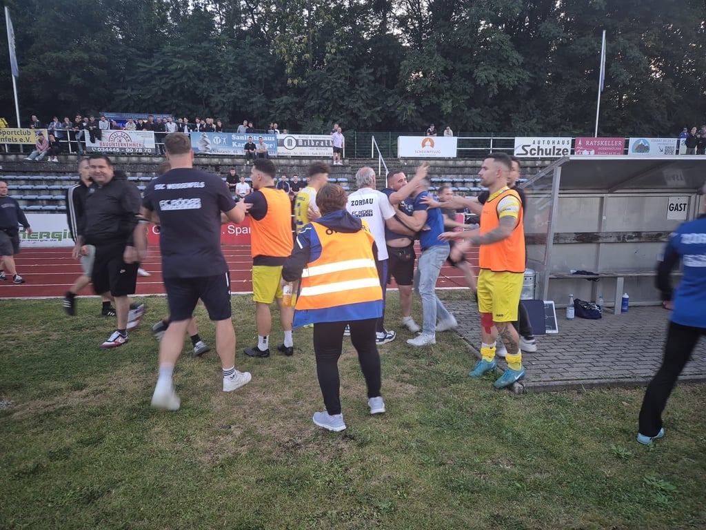 Weißenfelser Spieler stellen sich schützend vor die Zorbauer Bank. Warum gab es nicht mehr Sicherheitsvorkehrungen?