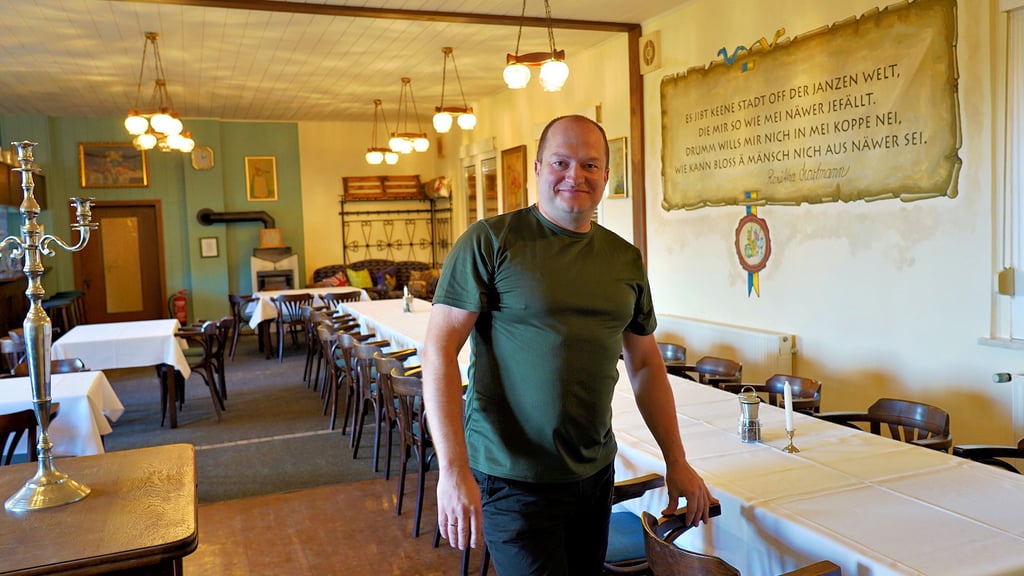 Nebras Gastronom Sebastian Sieber steht in dem – nach Entfernung einer bestehenden Trennwand – nun sehr großzügig dimensionierten Gastraum des Lokals „Neue Liebe“. Rechts hinten an der Wand prangt das Kult-Zitat zu „Näwer“.